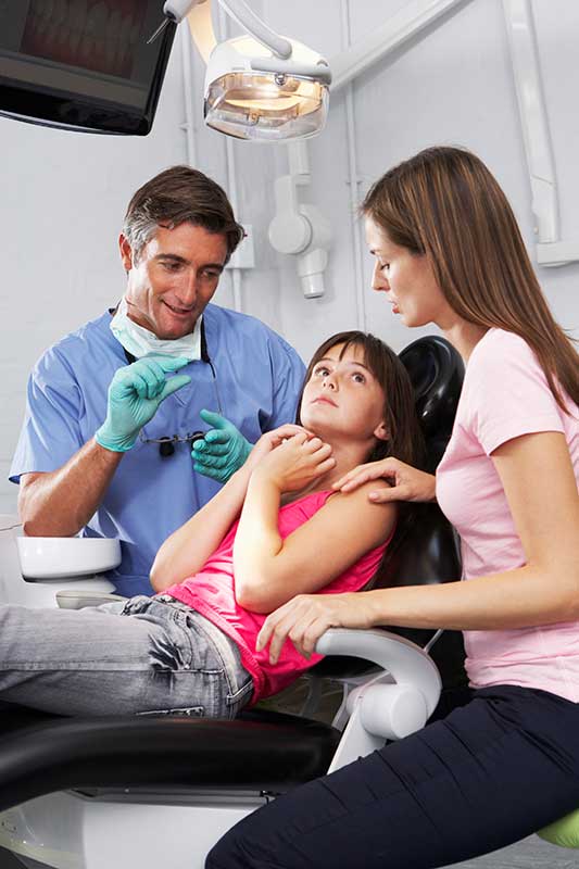 little girl fearing the dentist as the doctor explains sedation dentistry 